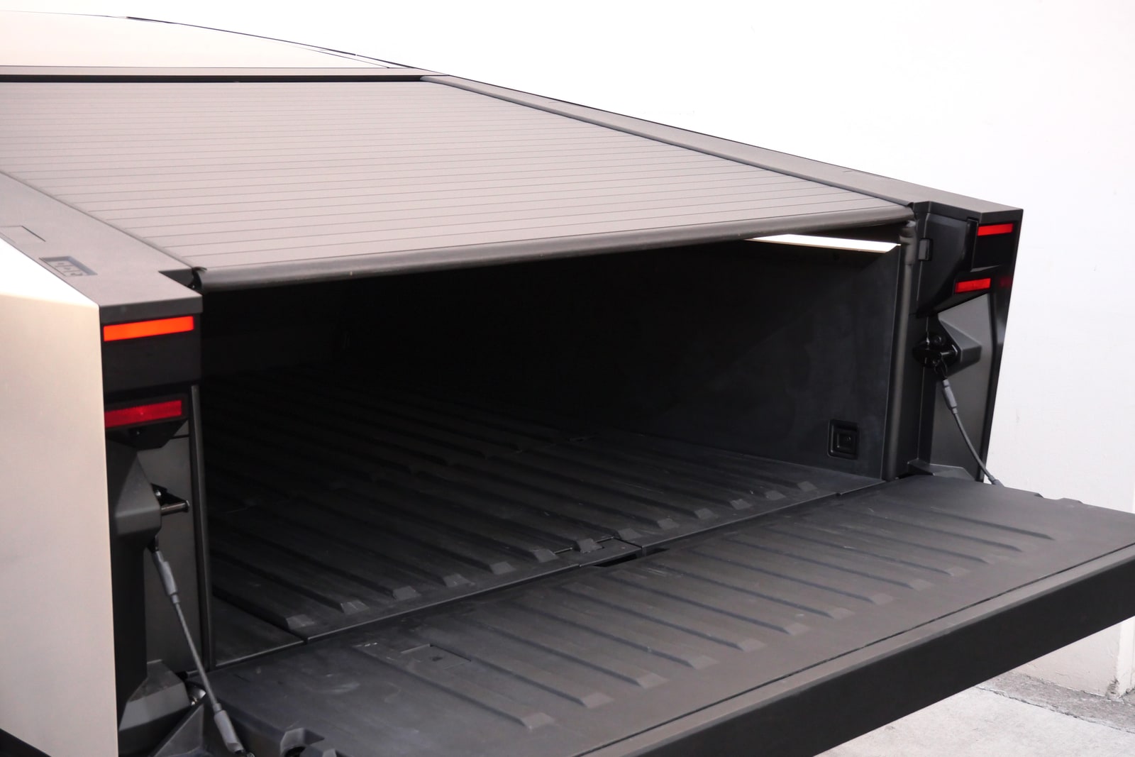Bed of the Tesla Cybertruck with the powered tonneau cover rolled back